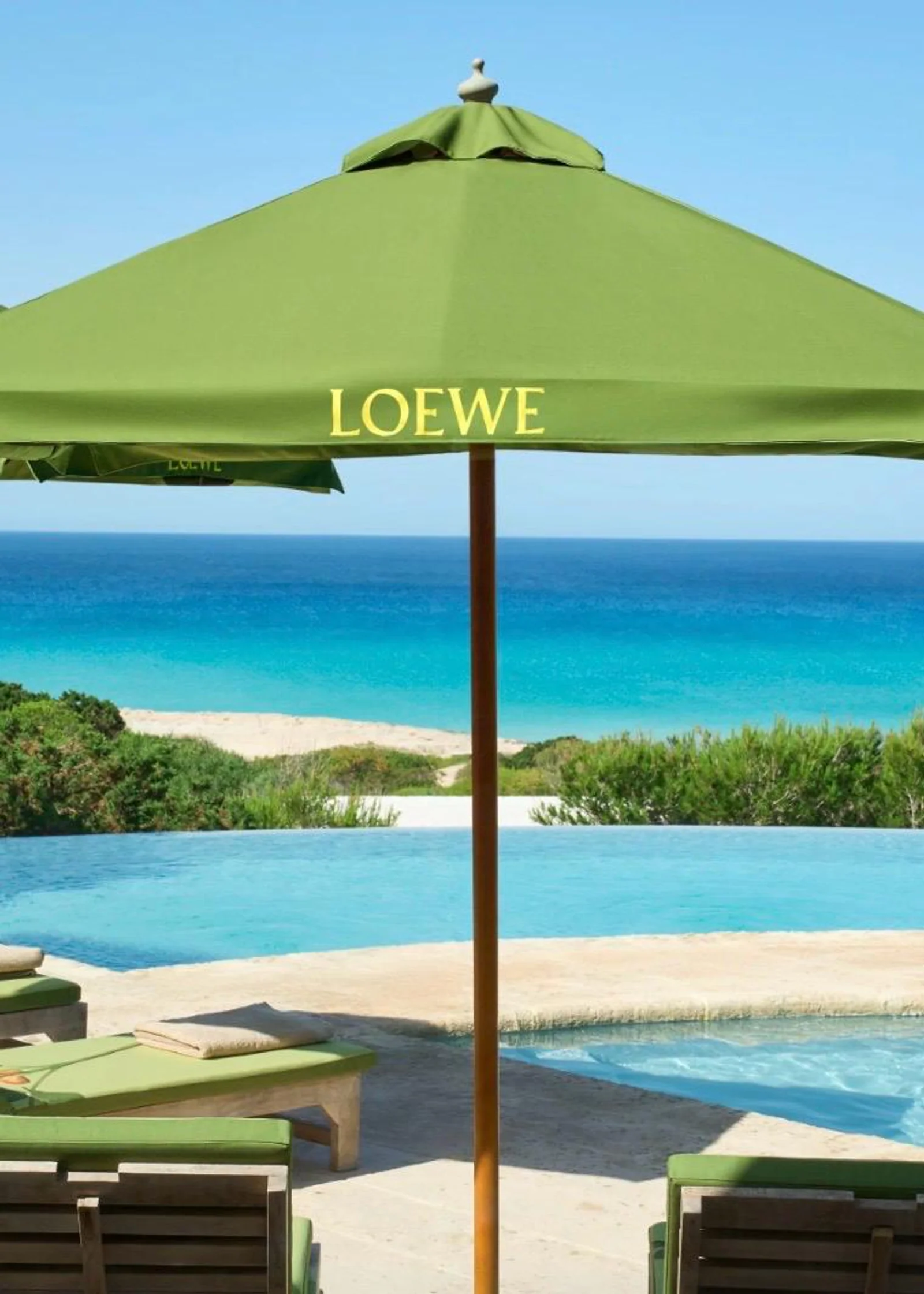 Loewe Perfumes präsentiert Pistachio auf Formentera Grüner LOEWE-Sonnenschirm am Hotel Dunas de Formentera, wo Loewe Perfumes die neue Pistachio Duftkerze in einer sommerlichen Installation präsentiert.