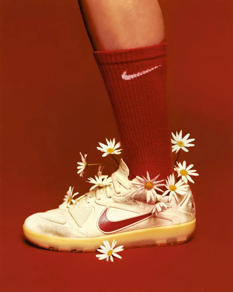 Nike Sneaker mit roten Fußballsocken und floralen Details als Teil des aktuellen Fußballmode-Trends.