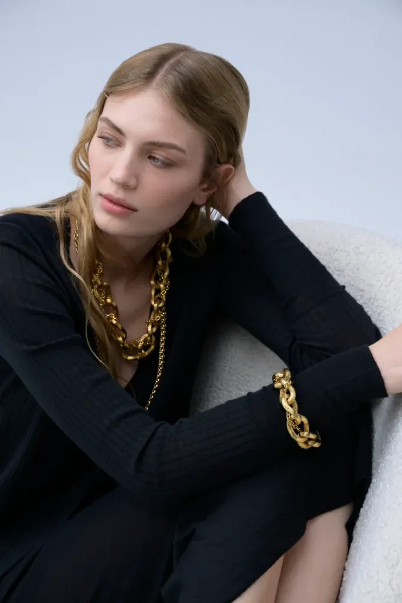 Model trägt vergoldete Kette und Armband aus der ersten Schmuckkollektion von Malo