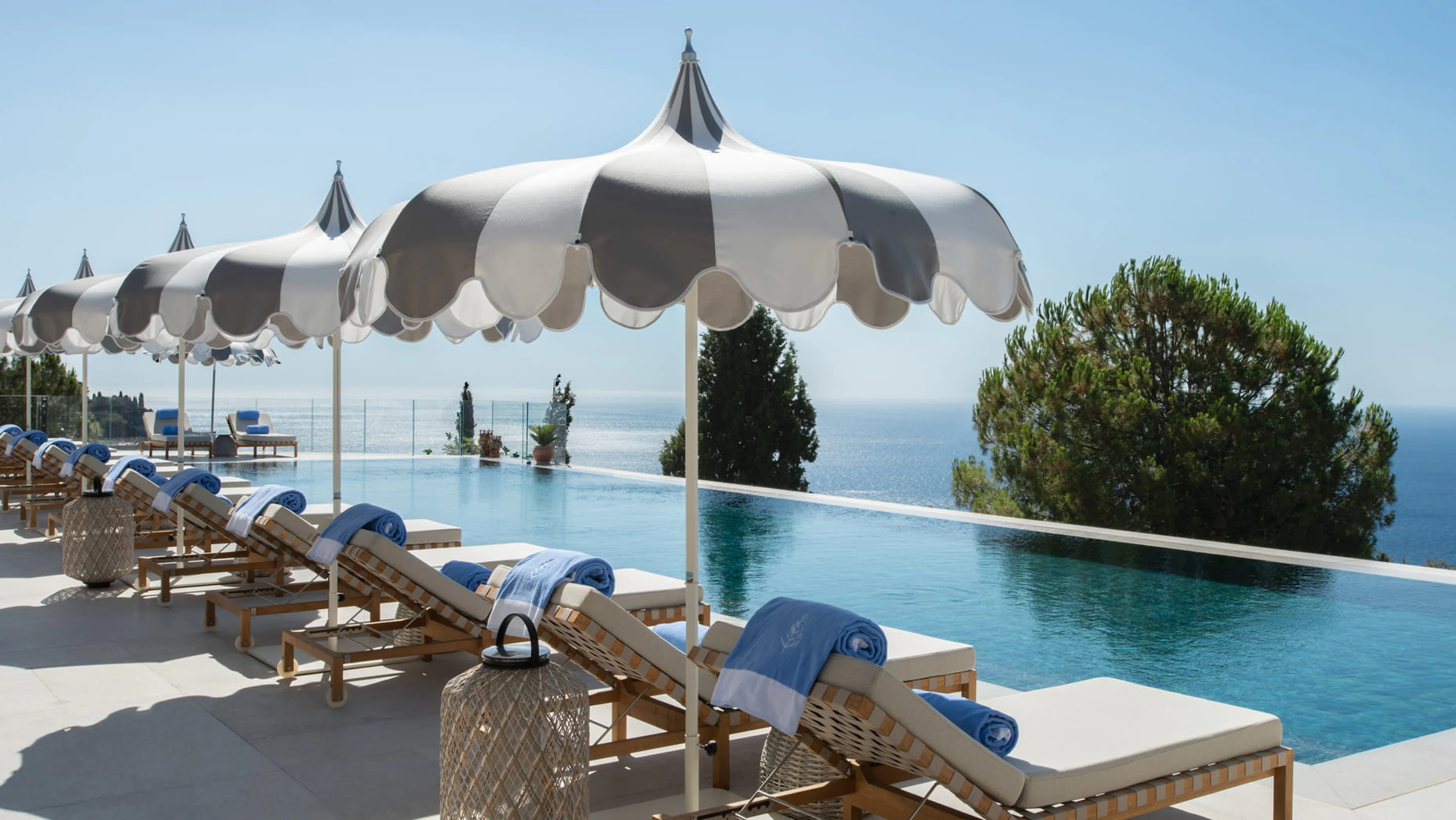 Poolterrasse des Four Seasons San Domenico Palace in Taormina mit Sonnenschirmen und Meerblick