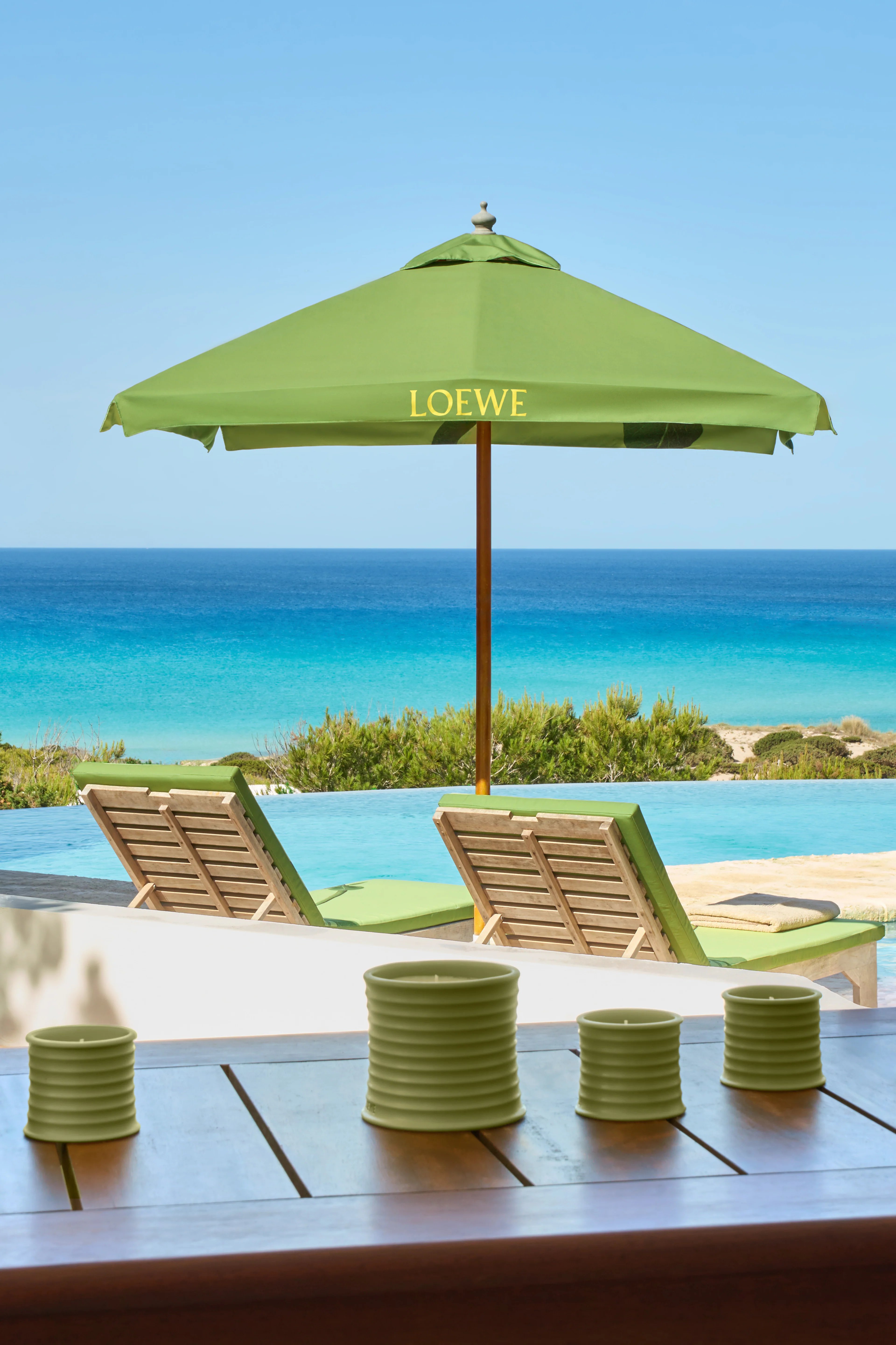 LOEWE Pistachio Duftkerzen auf der Terrasse des Hotels Dunas de Formentera mit Blick auf Strand und Mittelmeer.