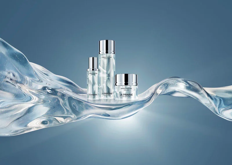 Die dreiteilige La Prairie Swiss Pristine Kollektion bestehend aus Essence, Serum und Cream vor einem hellen Hintergrund.