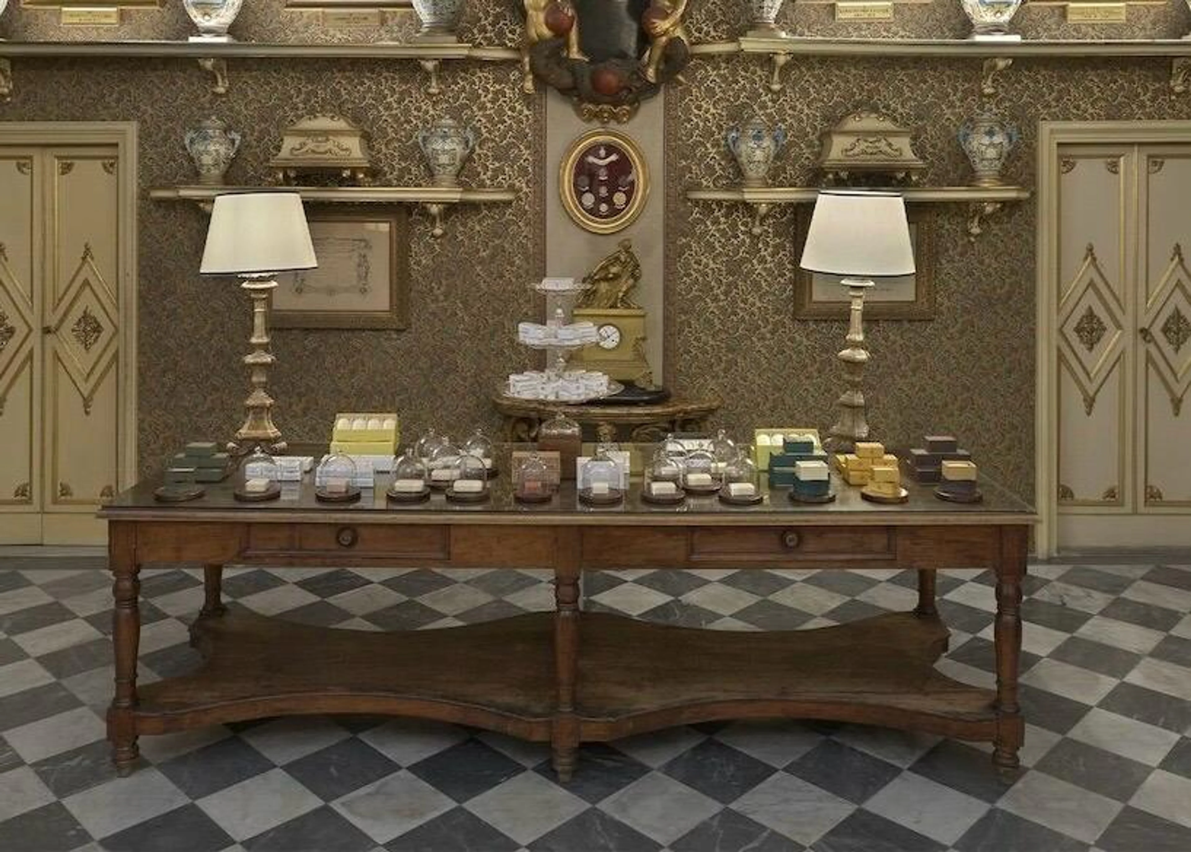Historischer Verkaufsraum der Officina Profumo-Farmaceutica di Santa Maria Novella in Florenz mit edlen Seifen auf einem Holztisch und antikem Interieur.