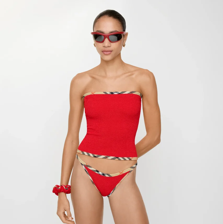 Model trägt roten Bikini mit Burberry-Check-Details aus der Burberry x Hunza G Swimwear-Kollektion.