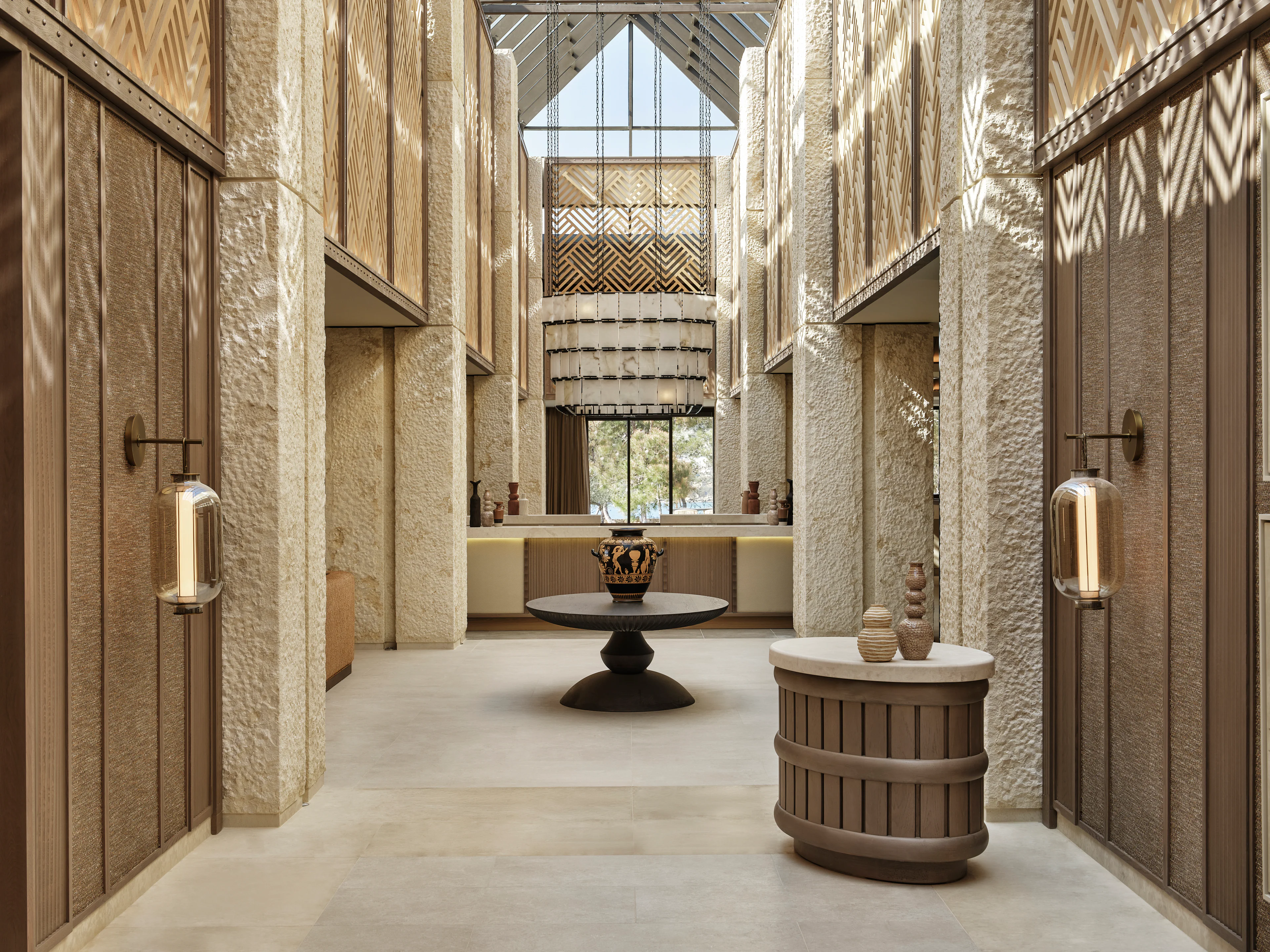 Lichtdurchfluteter Eingang des Restaurants im AMOH Luxury Collection Resort mit Naturstein und warmen Erdtönen.