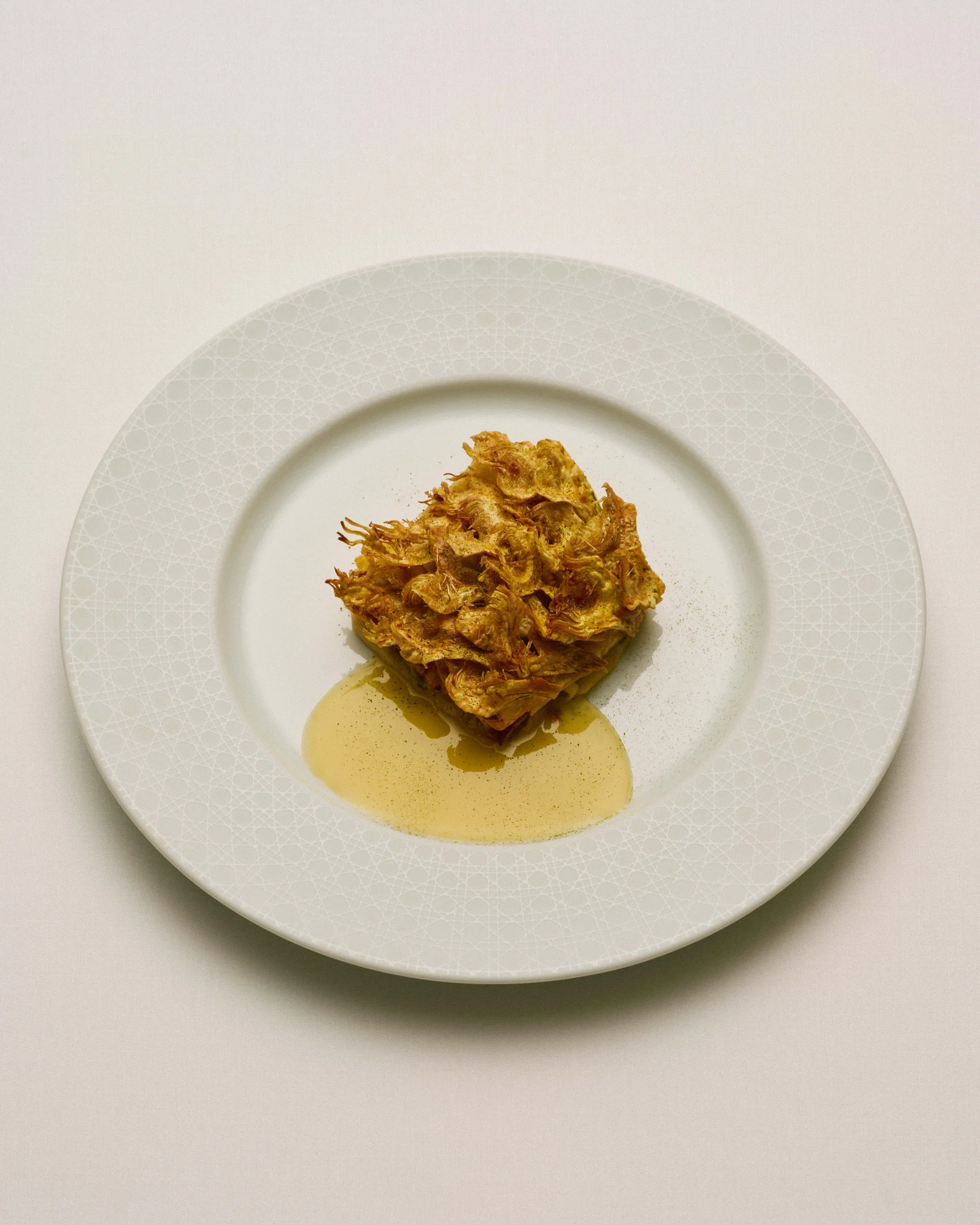 Knusprig angerichtete Artischocke mit Sauce im Restaurant Monsieur Dior Paris