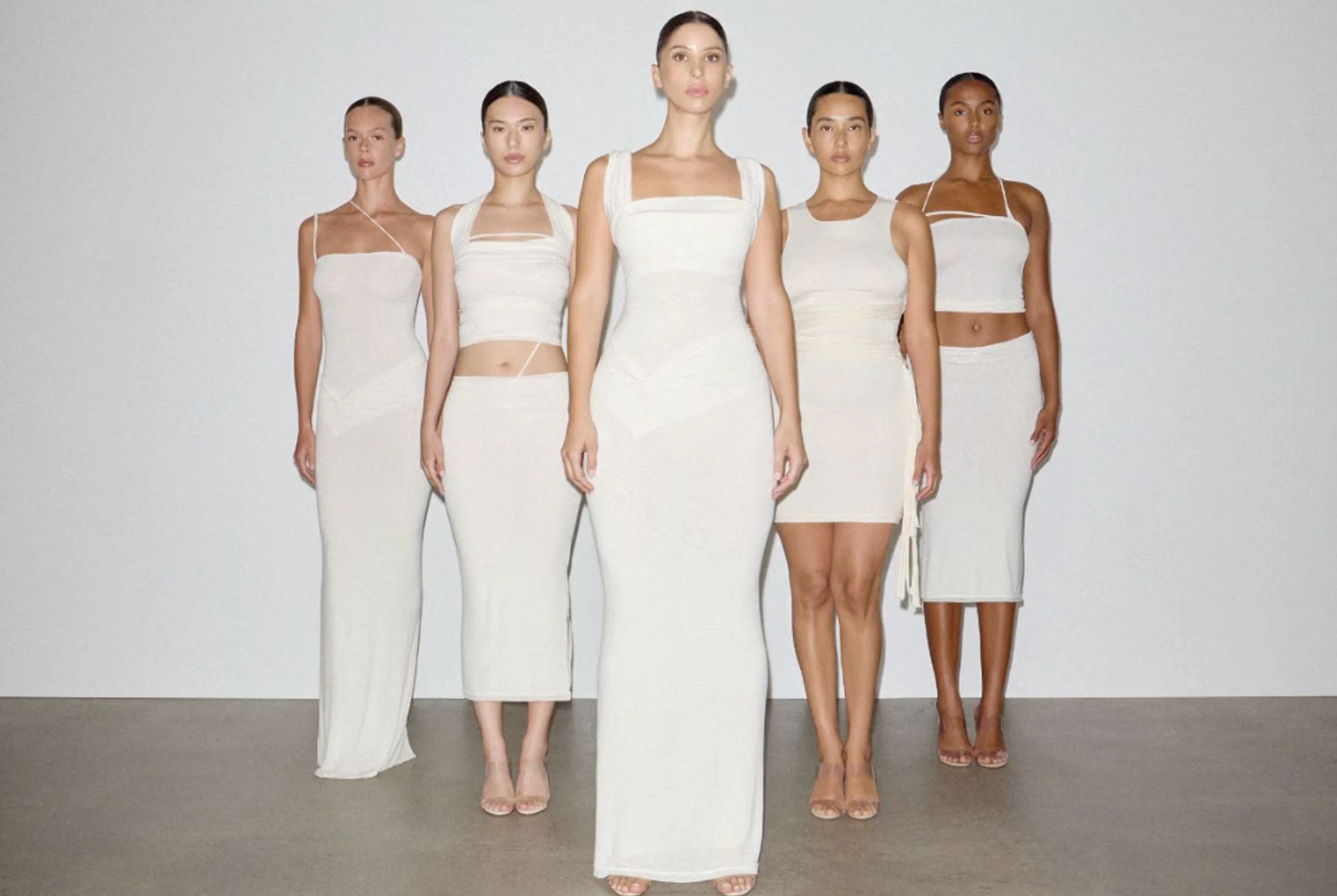 Models tragen weiße Kleider in unterschiedlichen Silhouetten aus der gemeinsamen Kollektion von Skims und Vettese.