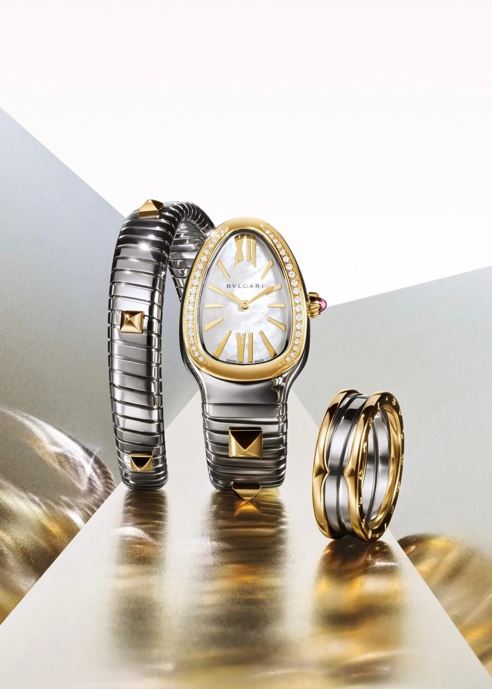 Bulgari Serpenti Tubogas Uhr und Ring Eine Bulgari Serpenti Tubogas Damenuhr aus Gold und Edelstahl mit Diamanten neben einem passenden Bulgari-Ring.