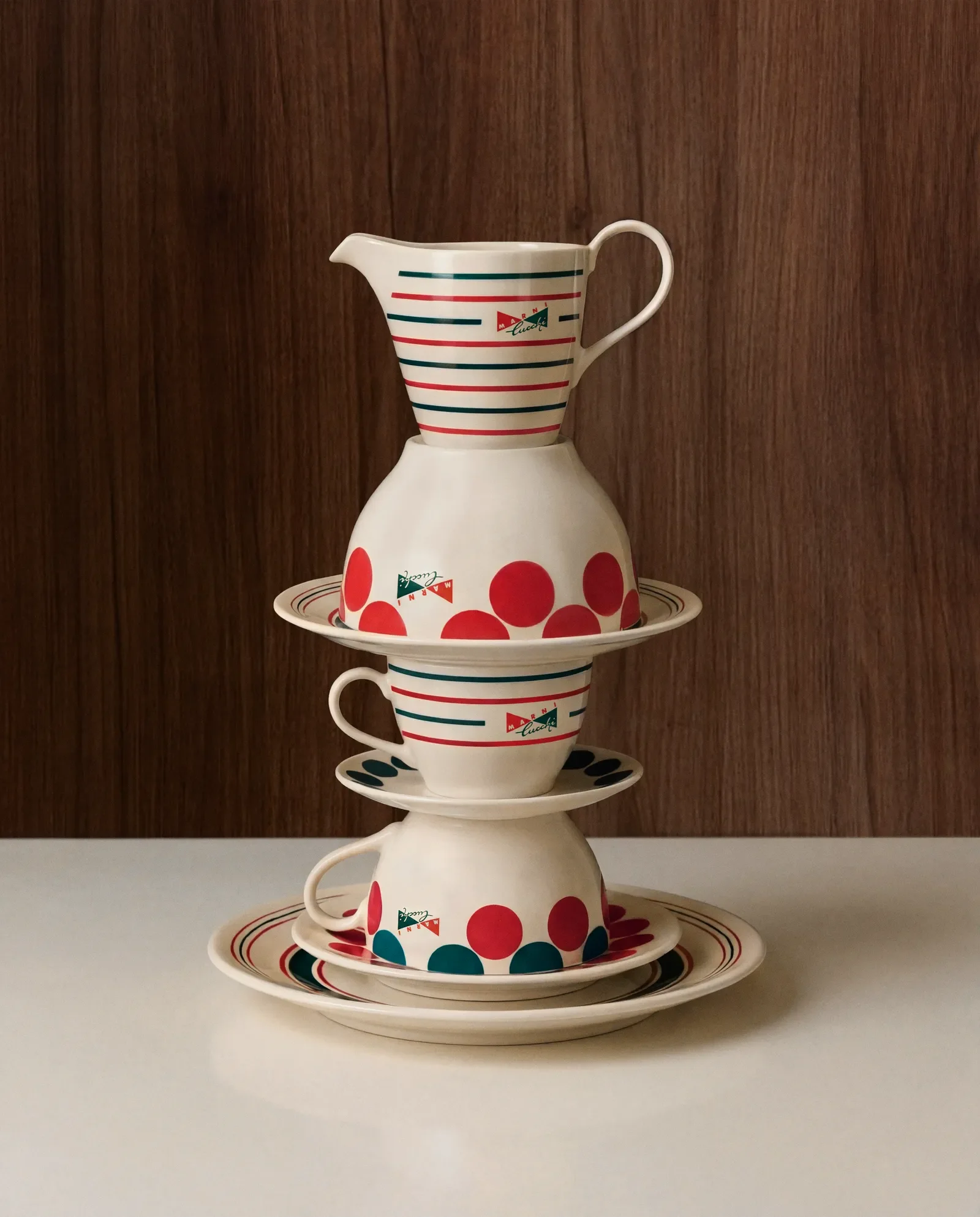 Gestapeltes Marni x Cucchi Geschirr mit Punkten und Streifen auf Tisch vor Holzpaneel