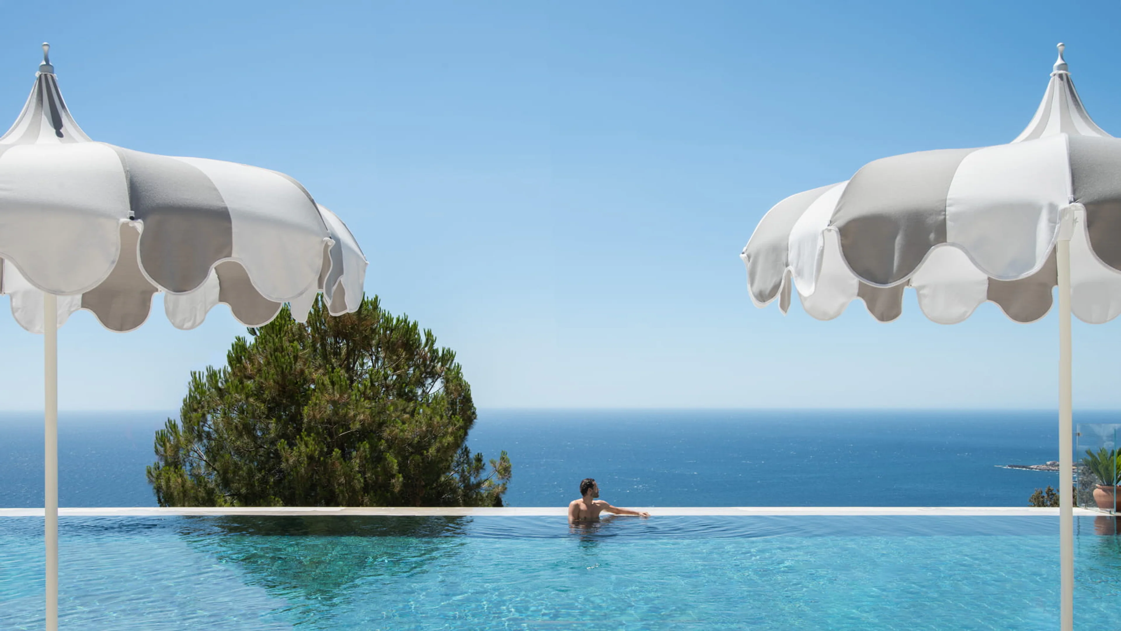 Gast im Infinity-Pool des San Domenico Palace in Taormina mit Blick auf das Ionische Meer