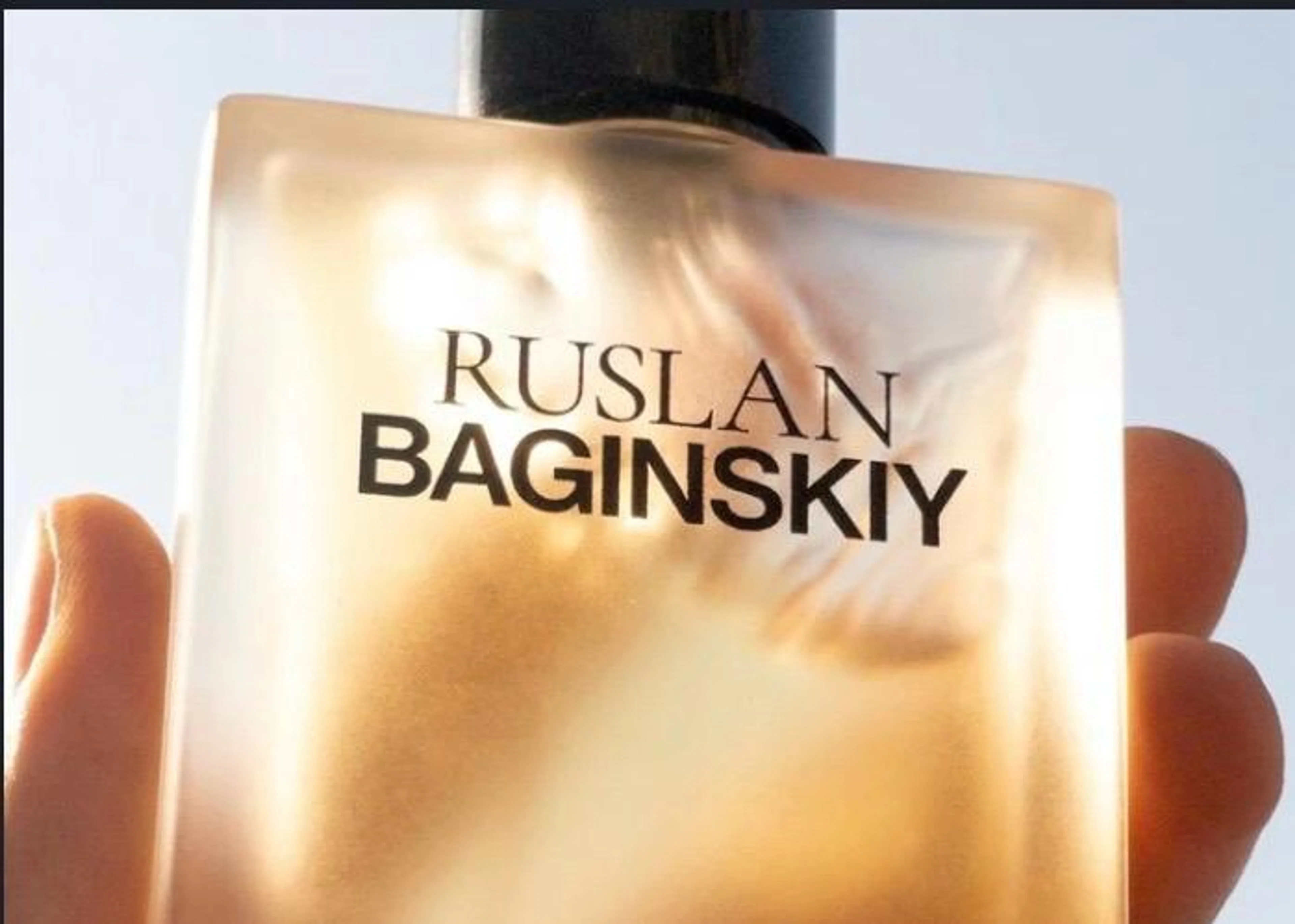 Hand hält das Parfum Grain de Sel von Ruslan Baginskiy vor hellem Hintergrund.