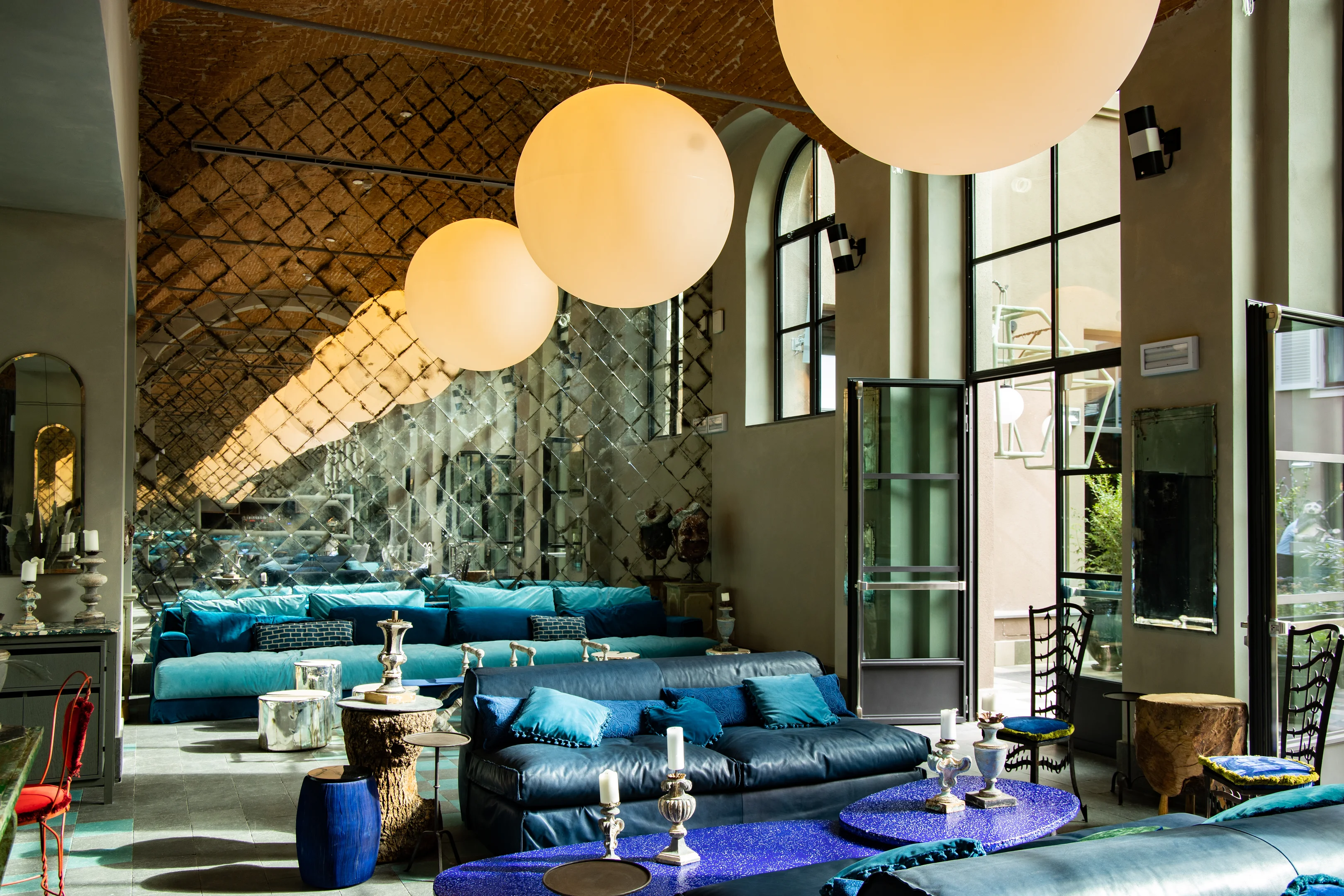 Stilvolle Lobby mit blauen Sofas und Gewölbedecke im 25hours Hotel Florenz.