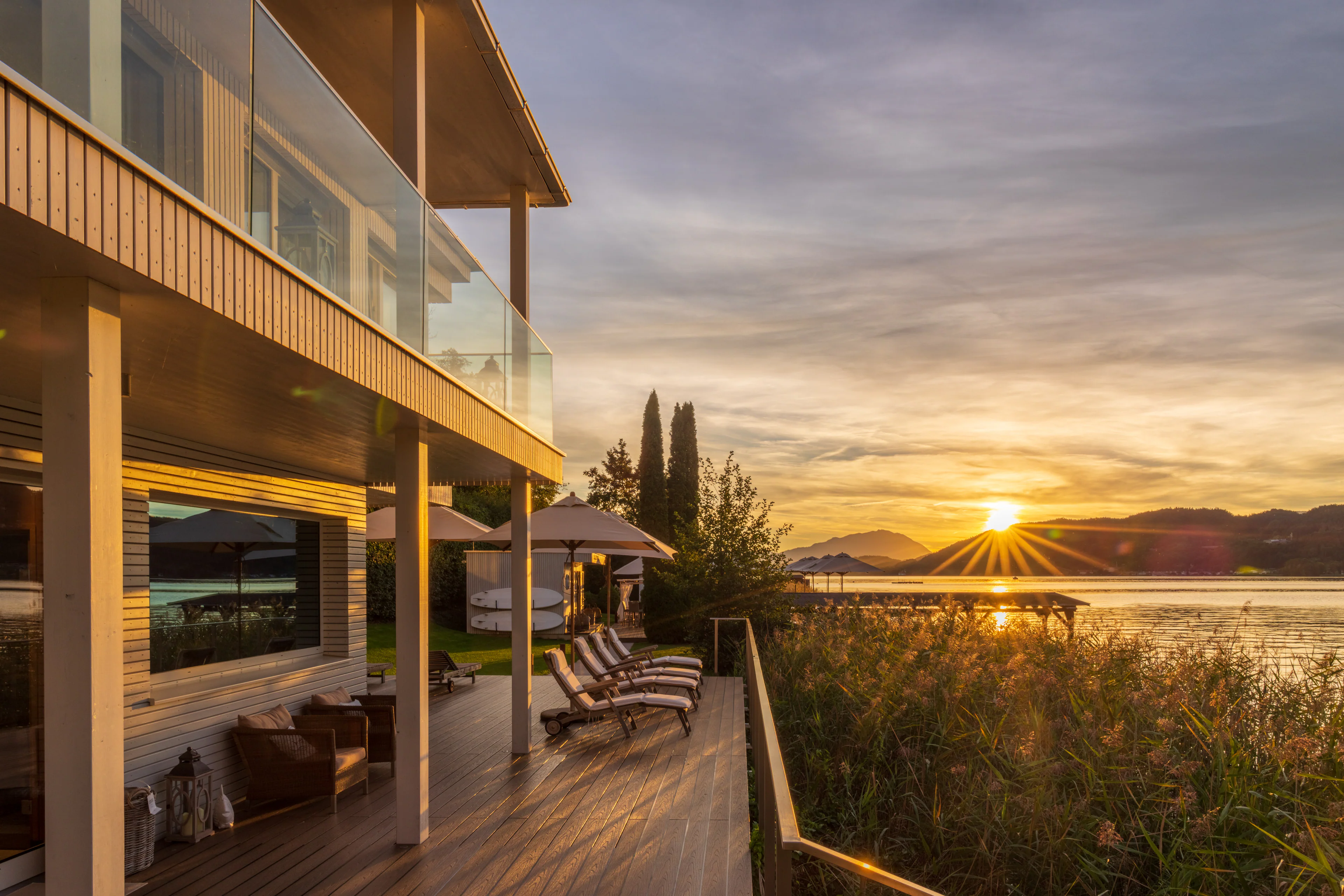 Terrasse eines Health Resorts direkt am See während des Sonnenuntergangs.